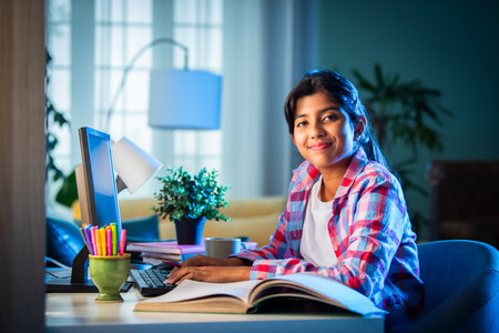 Indian asian teenage girl studying at home using personal computer, home education conceptの写真素材