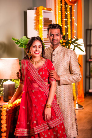Portrait of happy young indian couple in traditional wear looking at cemara with happinessの写真素材