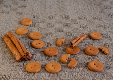 Round brown cracker and cinnamon on the linen tableclothの写真素材