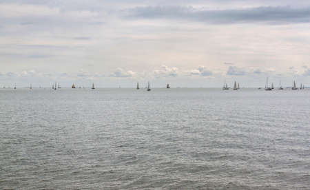 Many yachts on the horizont in sea in cloudy dayの写真素材
