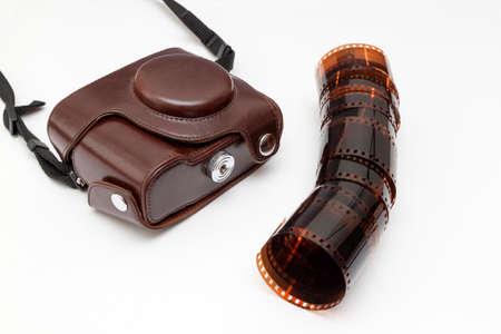 old camera in case and blank film roll on white backgroundの写真素材
