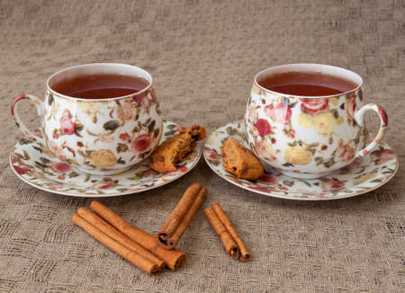 Two cups of tea with cookie and cinnamonの写真素材