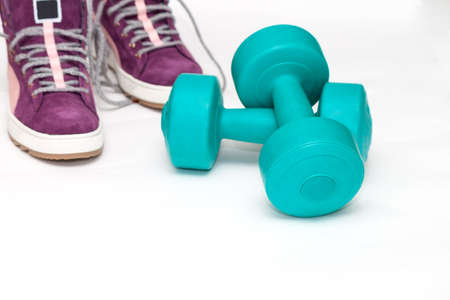 Fitness and sport equipment :sneakers and dumbbells on white backgroundの写真素材