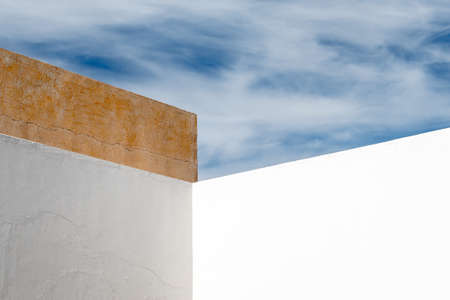 Abstract Angular White Wall with White Clouds and Blue Skyの写真素材