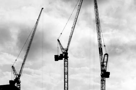 Construction Cranes and Buildings Silhouetted against skyの写真素材