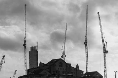 Construction Cranes and Buildings Silhouetted against sky in Black and Whiteのeditorial素材