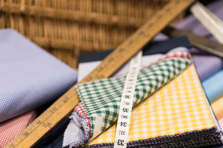 Brightly Colored Swatches in Wicker Basket with Wooden Rulers, Measuring Tape and Scissorsの写真素材