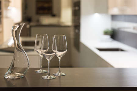 Empty Glasses and Wine Carafe in Stylish Modern Kitchenの写真素材