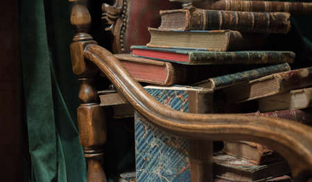 Vintage baroque armchair with old books against green curtainの写真素材