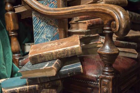 Vintage baroque armchair with old books against green curtainの写真素材