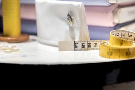 Tailor's Table with Thread and Tape Measure and Shirt Cloth Swatches
