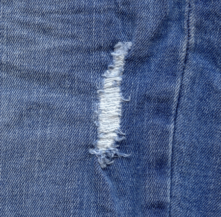 Denim texture, torn jeans. Modern design of the old wearing ripped jeans