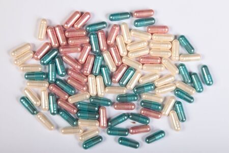colored capsules tablets scattered on the tableの写真素材