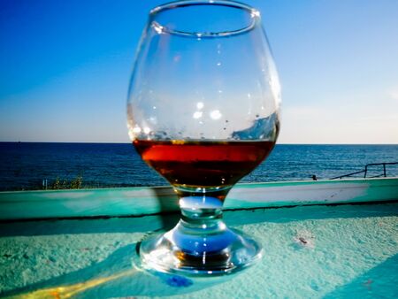a glass with a drink on the background of the seaの写真素材