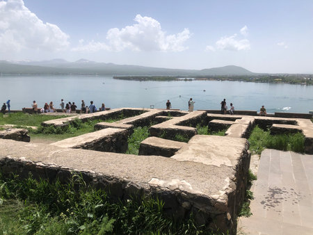 Ruins on a grassy hill overlook Lake Sevan in Armeniaの写真素材