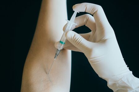 Nurse who is going to inject into the arm with a syringe. Drug or self-medication related.の写真素材