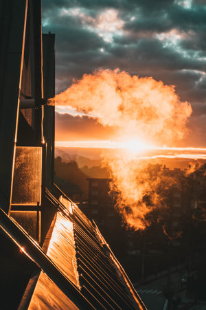 Beatiful smoke vent, on the roof of a flat because of the gas heating on a cold day with a spectacular sunset. Natural vent expel smoke outside using the exhaust pipe.の写真素材