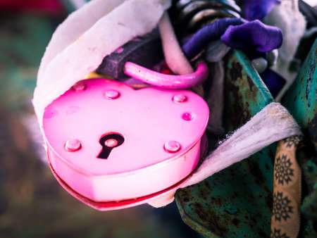 Pink heart lock on a fenceの写真素材