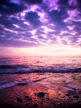 Wonderful view of the sunrise on the sea coast with colored cloudsの写真素材
