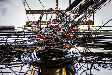 Tangled electrical wires on urban electric pole.の写真素材
