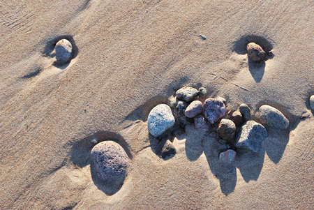 Beautiful stones on the frozen sand on the Gulf coast in autumnの写真素材