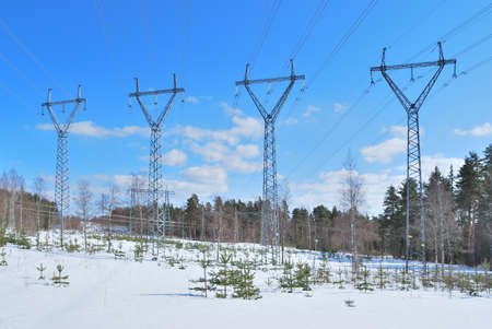 Electricity transmission lines pylons on the  background of blue sky in a sunny spring dayの写真素材