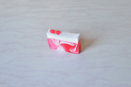A piece of beautiful handmade strawberry soap, decorated with strawberriesの写真素材