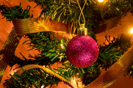 Purple Christmas ball hanging from the Christmas tree, there is a golden ribbon.の写真素材