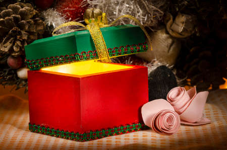 Christmas gifts with gold ribbon whit two pink roses, there is a pinecone and a partial santa in the...