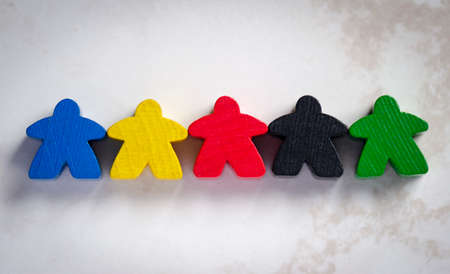 5 multicolored meeples holding hands, board game, concept of unity and diversity.の写真素材