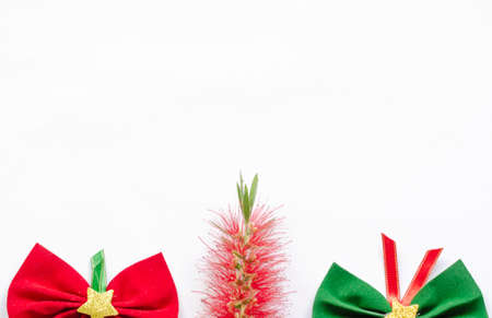 flat lay christmas decoration with white background and copy space, one red and one green ribbon.