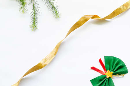 xmas background, one golden ribbon dividing the image, on one side is a branch of plants on the...