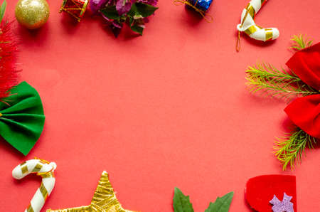 christmas ornament frame on red background, there are bows, canes, plants and presents. flat lay, copy space.の写真素材