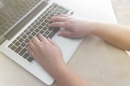 Hands of a young girl typing on a laptop. Writing on computerの写真素材