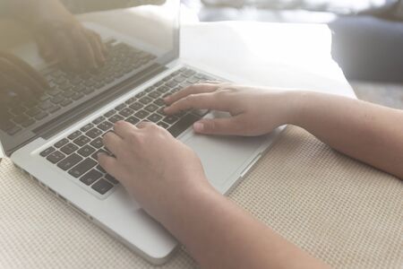 Hands of a young girl typing on a laptop. Writing on computerの写真素材