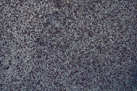Photograph of a grainy texture on the floor of a children's playground. Outdoor texture and wallpaper. rubber flooringの写真素材