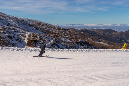 Person snowboarding the snowy mountain of Sierra Nevada, Granada, during the winter.の写真素材