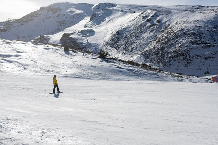 Person snowboarding the snowy mountain of Sierra Nevada, Granada, during the winter.の写真素材