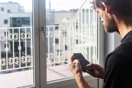 This collection of images features a man in his young adult years seated in a chair next to a window...