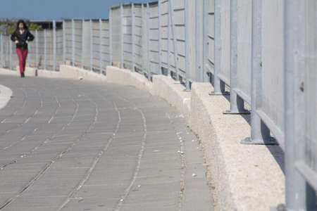 a lonely girl walking  by the fenseの写真素材