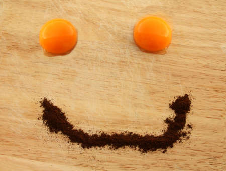 egg yolk eye coffe smile on wooden boardの写真素材