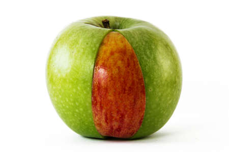 green apple with red apple slice inside of itの写真素材