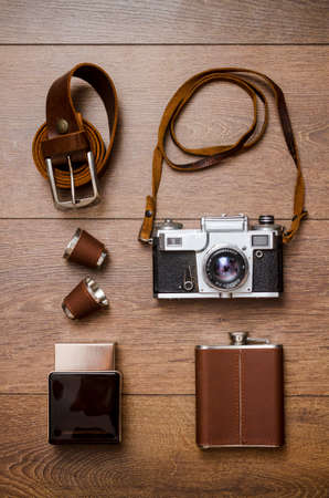 Vintage camera, perfume and leather belt on wooden floorの写真素材