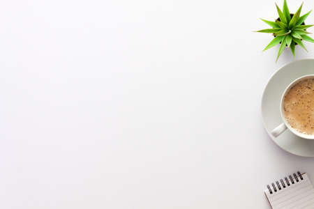 White table at home. Cocoa with foam in a white cup, notebook and succulent. An empty office desk from above. Copy spaceの写真素材