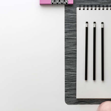 Office table top view with white space for your text. Black and white concept with pastel pink elements. Geometrical style with office toolsの写真素材