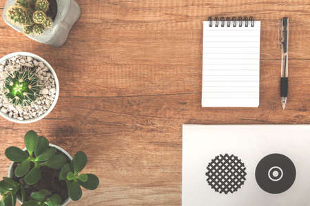 Top view on wooden desk with notebook, cactuses and penの写真素材