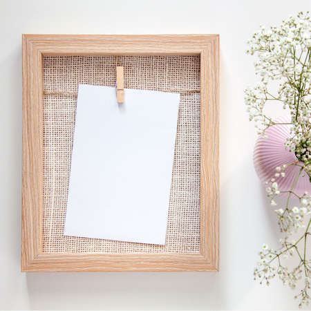 A wooden mockup frame with a white card and a pink vase with field dried flowersの写真素材