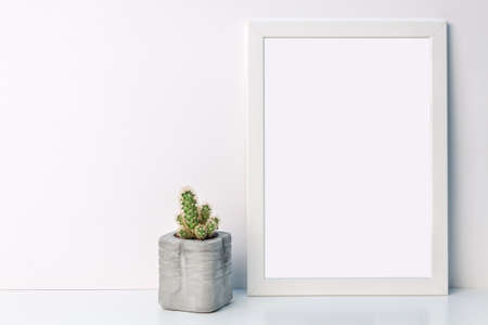 White mockup frame with a cactus in a concrete flowerpot on an empty white backgroundの写真素材