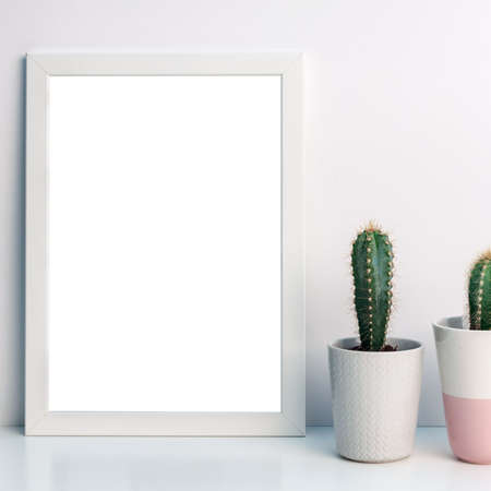 Panoramic photo of a white frame mockup with cactuses of a gray flowerpot with a pattern of sweater and one pastel pink terrazzoの写真素材