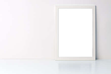 Photo of a white mockup frame on white blank wall copy space background on a white deskの写真素材